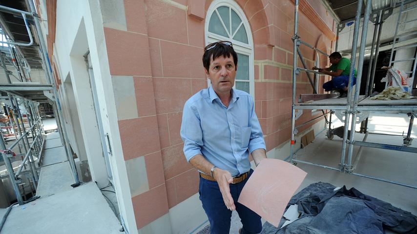 Projektleiter Thomas Riek mit den recycelten Sandsteinen der alten Krügelvilla, die als dünne Schicht auf den Betonnachbau im Lichthof des Forums aufgeklebt werden.