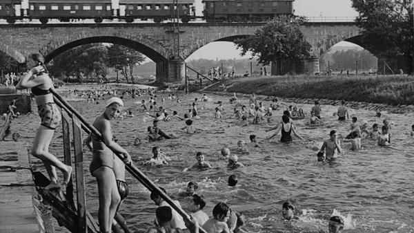 An heißen Tagen soll das Flussbad bis zu 12000 Badegäste angezogen haben. Ein Bild aus den 50ern mit Blick auf die Siebenbogenbrücke.