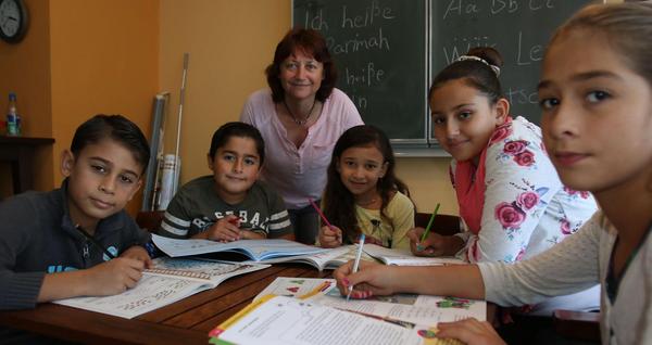 Ehrenamtliche unterstützen Flüchtlingskinder beim Lernen