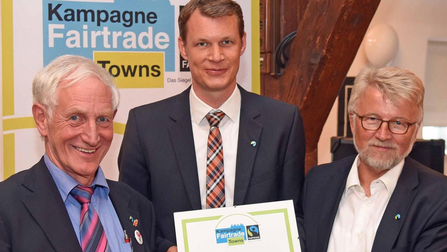 „Fairtrade-Ehrenbotschafter“ Manfred Holz (links) überreichte die Urkunde an OB Matthias Thürauf und Bürgermeister Roland Oeser.