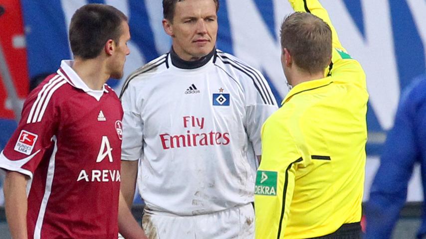 Referee Tobias Welz zeigt Hamburgs Torwart Frank Rost den Gelben Karton. Da Rost Christian Eigler links im Strafraum zu Fall gebracht hat, gibt es neben Gelb auch Elfer für den Club.