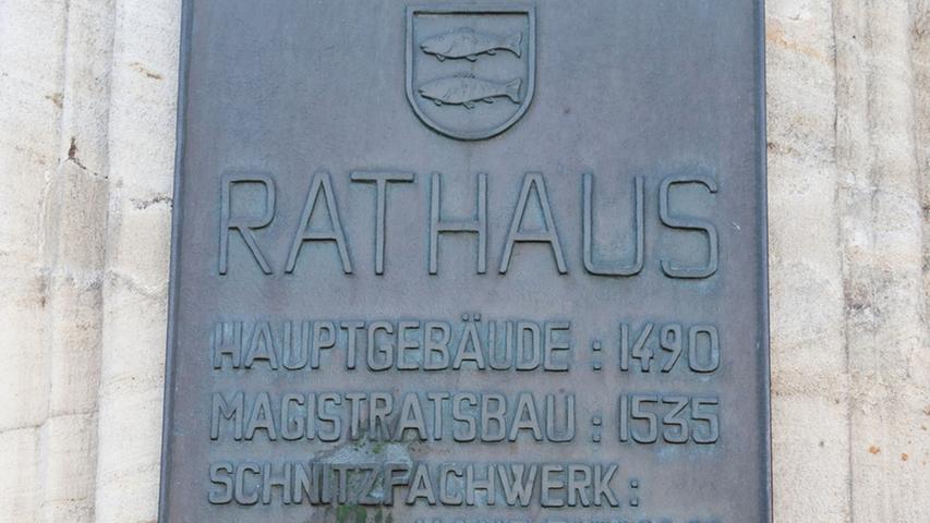 Ein Detail am Rathausplatz, die Bronzetafel mit der Legende für das Baudenkmal Rathaus.