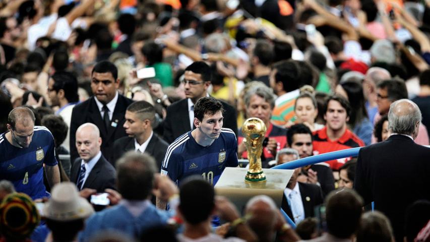 Er ist der beste Fußballspieler des Planeten - aber an diesem 13. Juli 2014 blieb Lionel Messi der Sprung auf den Fußball-Thron verwehrt. Im WM-Finale verloren seine Argentinier gegen Deutschland mit 0:1 nach Verlängerung. "La Pulga", der Floh, sieht sich die Trophäe aus der Nähe an. Wer weiß, wann er wieder so nah ran kommt.