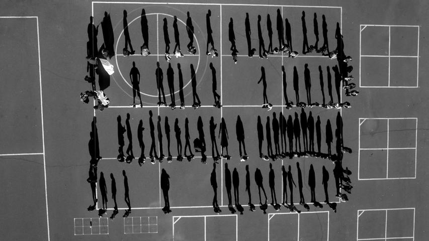 Nachdem einen Drohnenangriff 69 pakistanische Kinder in einer religiösen Schule in der Stadt Chenegai tötete, versammelten sich die Schüler auf einem Schulhof in El Dorado County, Kalifornien. Um dieses Foto aufzunehmen, benutzte der Fotograf ebenfalls eine Drohne.
