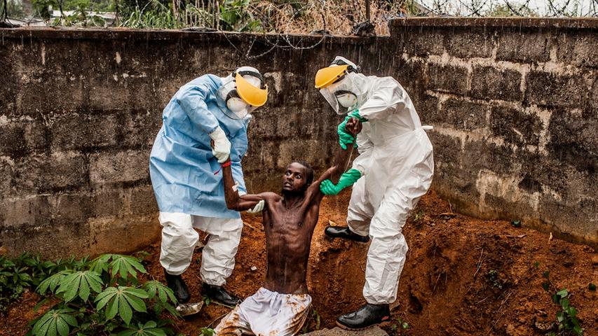 Hastings, Sierra Leone: Ein Ebola-infizierter Mann versucht, aus der Isolations-Abteilung des örtlichen Ebola-Centers zu entkommen. Zwei Mitarbeiter fangen ihn ein und bringen ihn zurück.