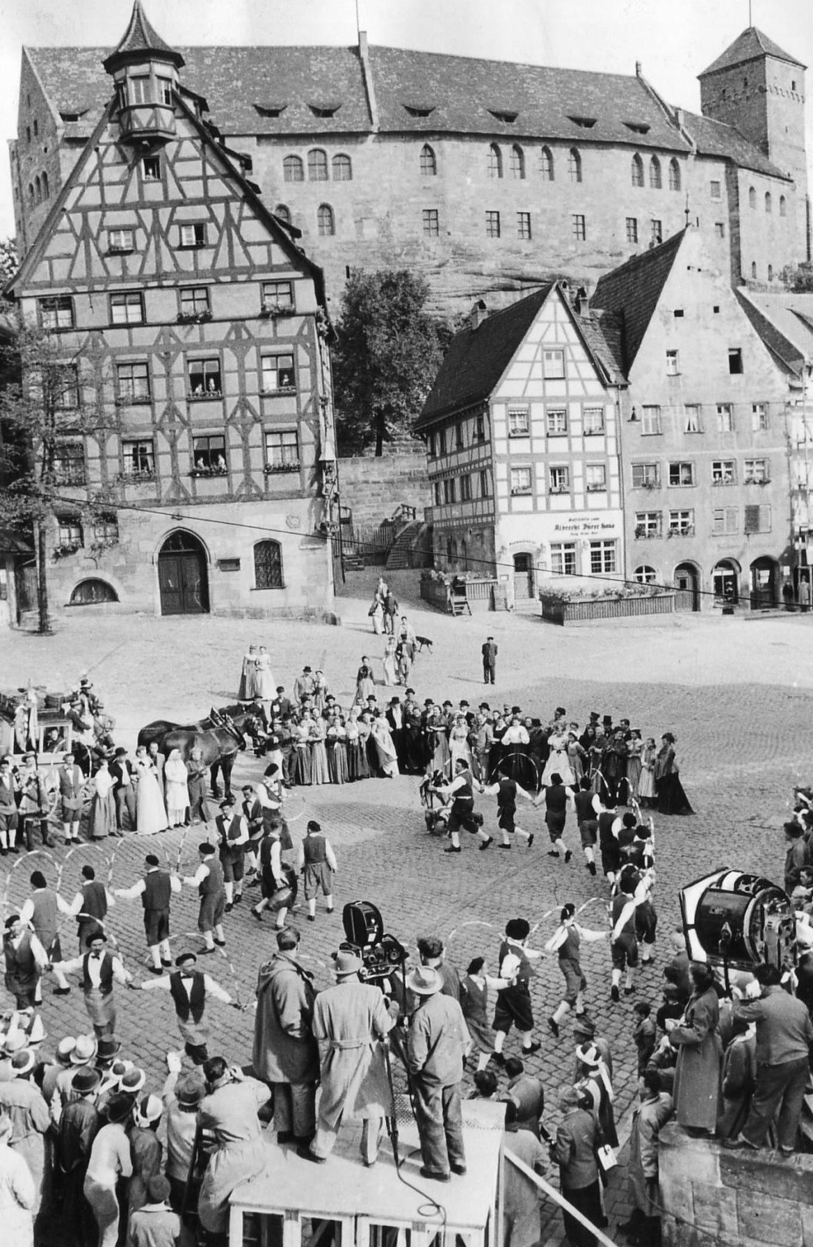 Nicht nur die Königsschlösser Nymphenburg, Hohenschwangau und Neuschwanstein oder der Markusplatz in Venedig, sondern auch Nürnberg bildete 1954 die Drehorte für Frauen um Richard Wagner (Orginaltitel: "Magic Fire"). Mit dem aufwendigen Kostümfilm wollte US-Regisseur William Dieterle Richard Wagner ein Denkmal setzen. Die Schembart-Gesellschaft verkörperte das jubelnde Volk auf dem Nürnberger Tiergärtnertorplatz, auf den Richard Wagner mit einer Postkutsche vorfuhr.