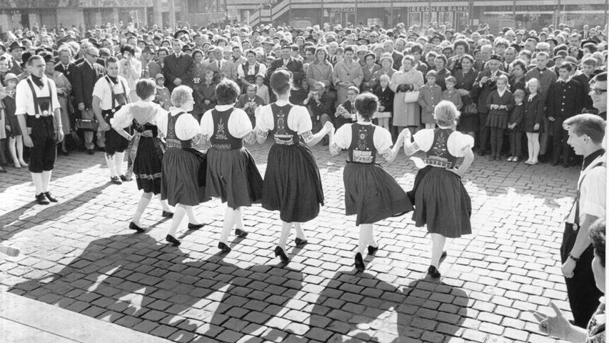 Im strahlenden Herbstsonnenschein zeigen Jugendgruppen aus Marburg und Gießen auf dem Hauptmarkt alte Egerländer Tänze. Hier geht es zum Artikel vom 11. Oktober 1965: Egerländer sind der Heimat treu