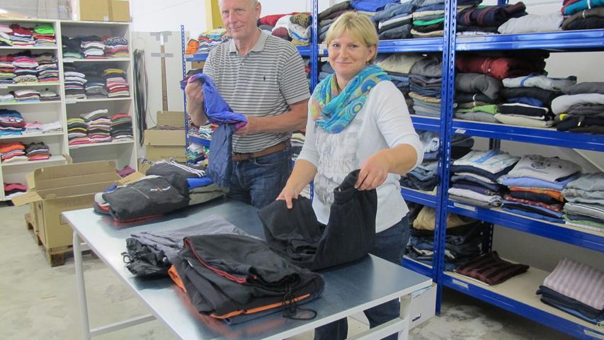 Ehrenamtliche Helfer sortieren in ehemaliger Schreinereihalle gebrauchte Kleidung für Flüchtlinge. Links: Helferkreis-Koordinator Roland Aechtner, rechts Martina Reitzammer.