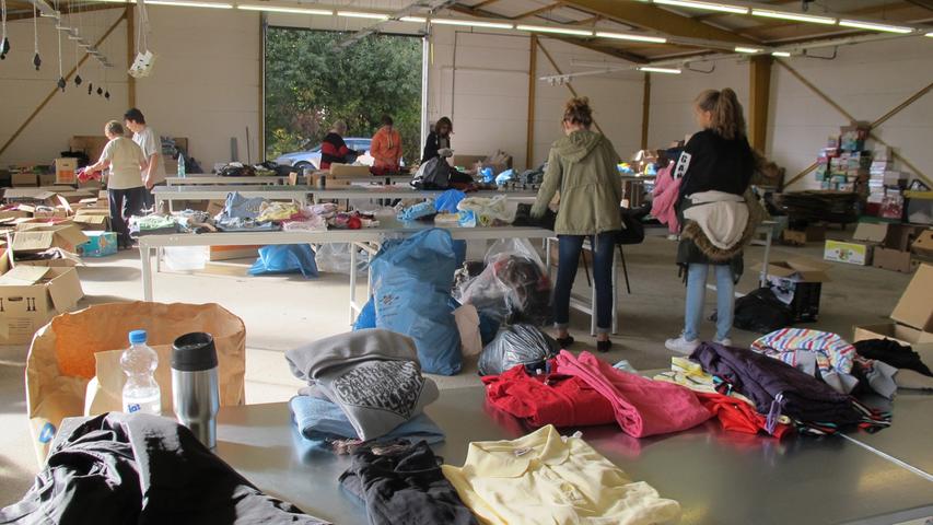 Ehrenamtliche Helfer sortieren in ehemaliger Schreinereihalle gebrauchte Kleidung für Flüchtlinge.