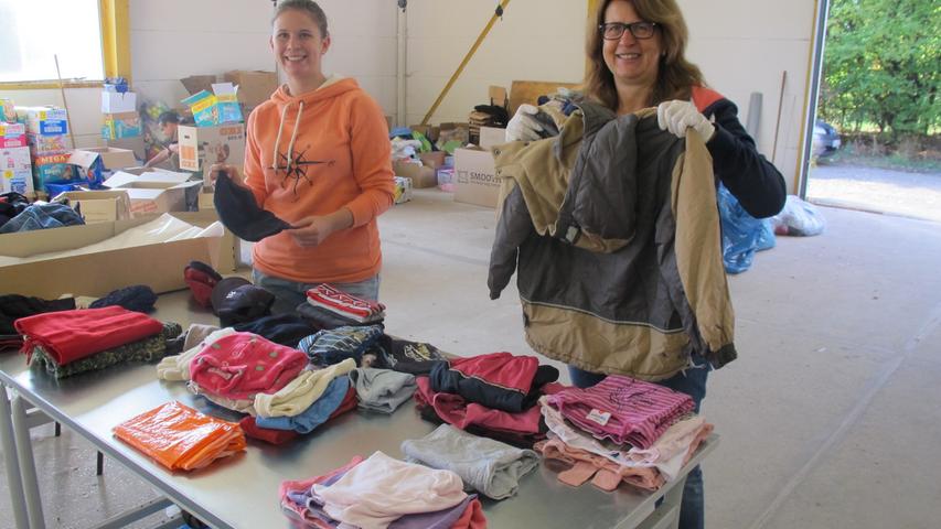 Die ehrenamtlichen Helferinnen Gabi Bittner (rechts) und Benita Burghardt, Mutter und Tochter, sortieren in ehemaliger Schreinereihalle gebrauchte Kleidung für Flüchtlinge.