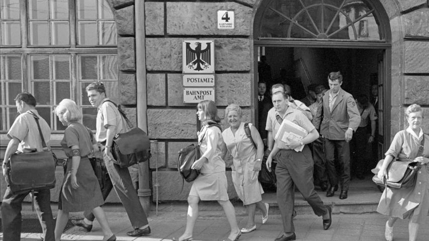 Auch bei dieser Aufnahme vom 31. Juli 1965 zeigt sich die Vielseitigkeit des Nürnberger Hauptbahnhofs. Mit Ferienjobs bei der dortigen Poststelle verdienten junge Leute etwas dazu. Zusammen mit den Männern und Frauen des Zustelldienstes verlassen kurz vor acht Uhr auch die von der Post eingestellten Schülerinnen und Schüler das Postamt.