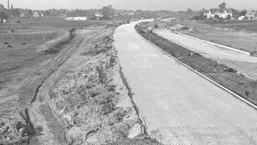 Ein Blick auf das geschwungene Band der "Knoblauchs-Autobahn", an der gegenwärtig emsig gebaut wird. Im Norden konnte bereits – erkennbar an der dunklen Farbe – der Bitumen-Unterbau hergestellt werden.
  Hier geht es zum Artikel vom 19. Oktober 1965: Mit Tempo am Knoblauch vorbei