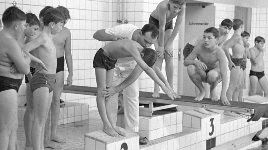 Keine Scheu, vor dem nassen Element zeigen die Fünf- und Sechsjährigen. Unter Aufsicht von Edi Sers werden sie von ihren Muttis in der Arbeit am Brett unterwiesen. Hier geht es zum Artikel vom 26. Oktober 1965: Ein jeder soll schwimmen können