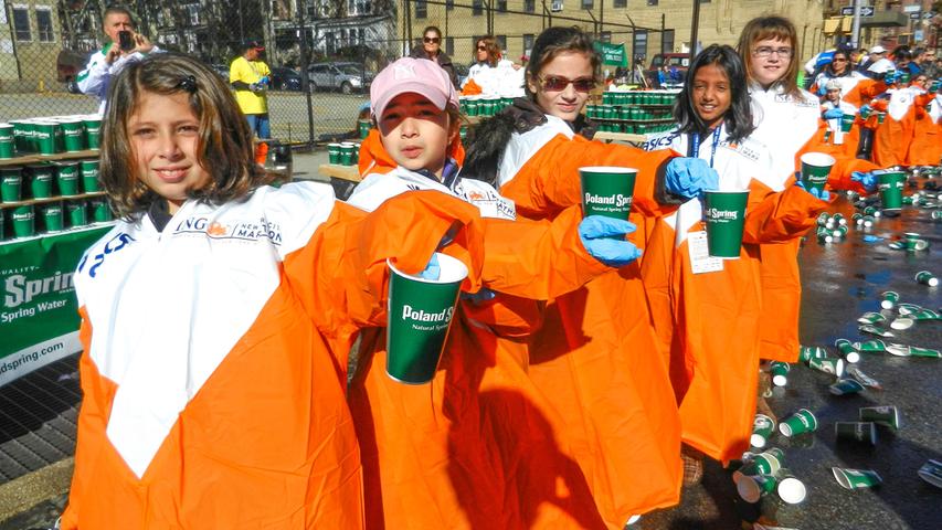 Freiwillige Helfer verteilen Getränke an der Strecke. Impressionen vom New York Marathon 2014