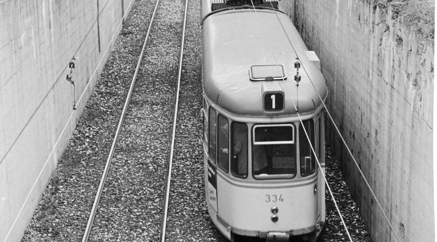 Nürnberg besitzt die erste deutsche Unterpflasterstrecke. Schon vor dem Kriege wurde der Tunnelabschnitt zwischen Bayern- und Münchener Straße gebaut. Hier rollt ein Straßenbahnzug gerade in eine Tunnelröhre. Er fährt noch im Einschnitt.
 
 Hier geht es zum Artikel vom 9. November 1965: Kommt doch Untergrundbahn?