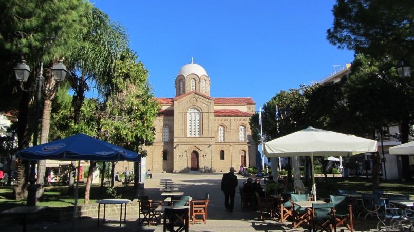 Am zentralen Platz laden viele Cafés und Restaurants zum Verweilen ein, im Hintergrund ist die Kirche Agios Vlasios zu sehen.