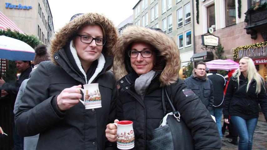 Janine (links) und Ramona kommen aus der Schweiz, auf dem regnerischen Christkindlesmarkt genießen sie eine warme Tasse Glühwein.