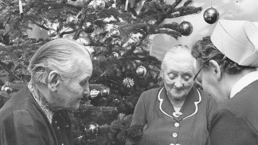 Weihnachtsfest im Altersheim an der Regensburger Straße: vor dem geschmückten Weihnachtsbaum liest Schwester Emmi den beiden Frauen aus der Bibel vor (rechts).Hier geht es zum Artikel vom 27. Dezember 1965: Friedliche Festtage in Franken