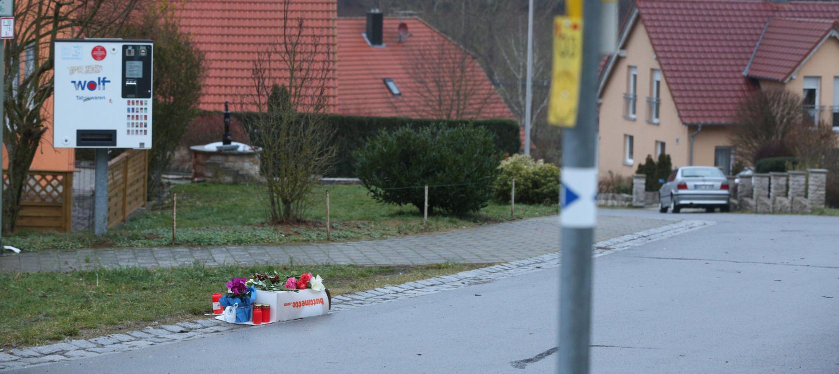 Der Schock sitzt tief: In Unterschleichach haben Trauernde Blumen und Kerzen am Tatort niedergelegt. Dort war eine Elfjährige von einem Projektil tödlich am Kopf getroffen worden.