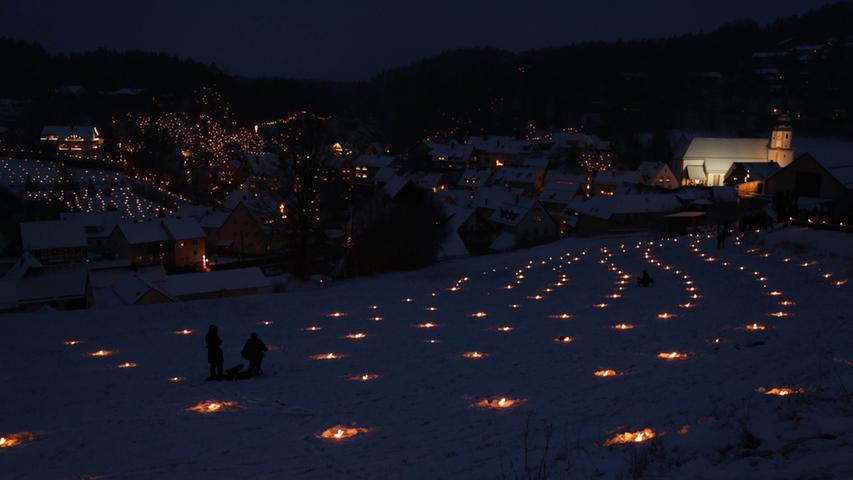 Tausende sind zur Ewigen Anbetung und der Lichterprozession nach Obertrubach gekommen. Monatelang haben 50 Obertrubacher das Spektakel vorbereitet. Gerade rechtzeitig fällt Schnee, so dass die Beleuchtung mit hunderten Kerzen und Fackeln in diesem Jahr besonders stimmungsvoll ist.