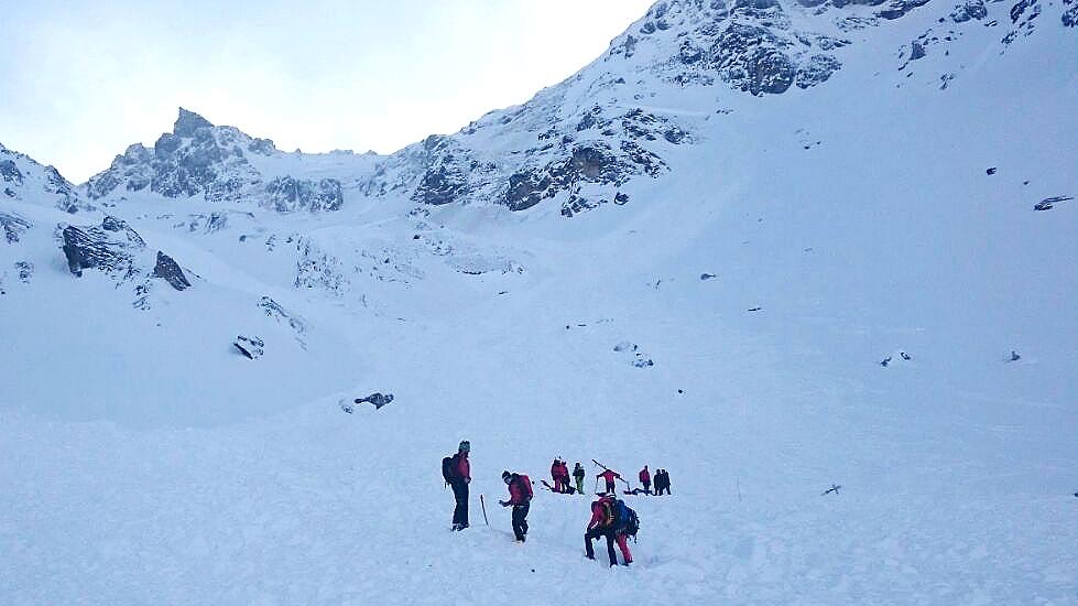 Einsatzkräfte suchen nach Verschütteten unter der Schneedecke. Zunächst war unklar wie viele Wintersportler vom Schnee begraben wurden.