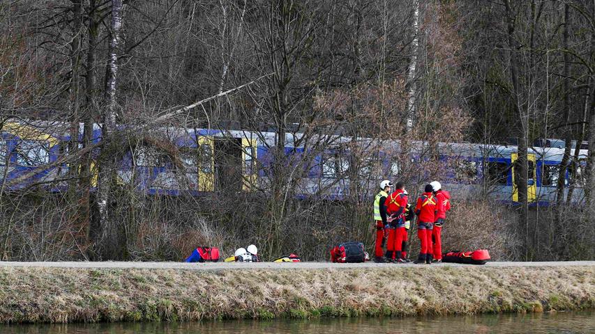 Members of emergency services stand next to a crashed train near Bad Aibling in southwestern Germany, February 9, 2016. Several people died after two trains collided in the southern German state of Bavaria on Tuesday, a police spokesman said, adding about 100 people were also injured. REUTERS/Michael Dalder
