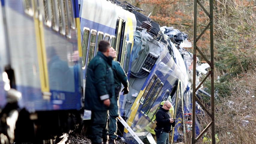 Members of emergency services stand at the site of the two crashed trains near Bad Aibling in southwestern Germany, February 9, 2016. Several people died after two trains collided in the southern German state of Bavaria on Tuesday, a police spokesman said, adding about 100 people were also injured. REUTERS/Michael Dalder