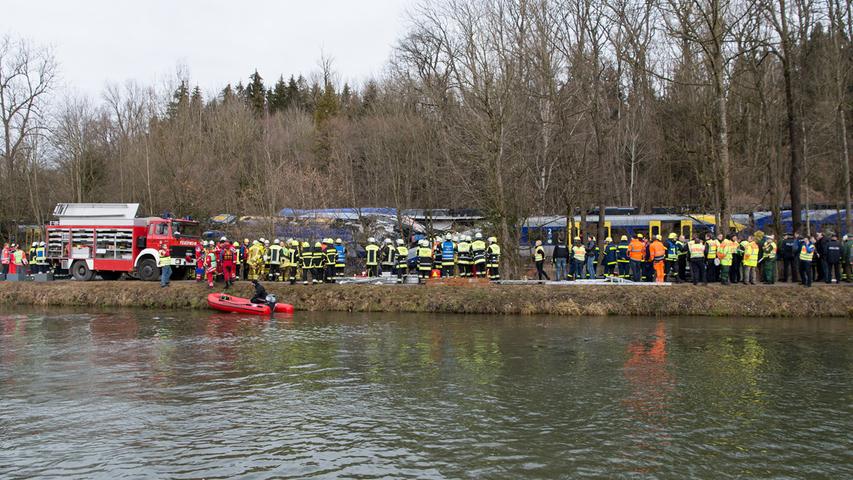 Members of emergency services stand at the site of the two crashed trains near Bad Aibling in southwestern Germany, February 9, 2016. Several people died after two trains collided in the southern German state of Bavaria on Tuesday, a police spokesman said, adding about 100 people were also injured. REUTERS/Michael Dalder