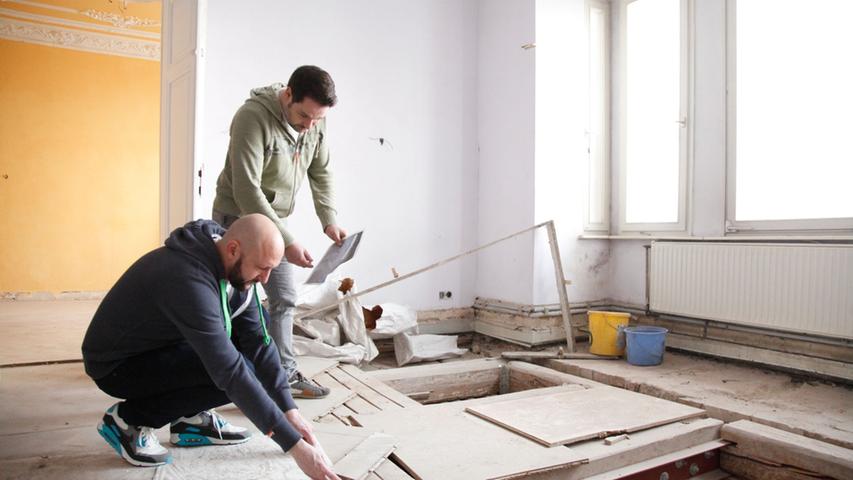 Hendrik Biehl (li.) und Markus Heusch begutachten einen kaputten Holzboden. 