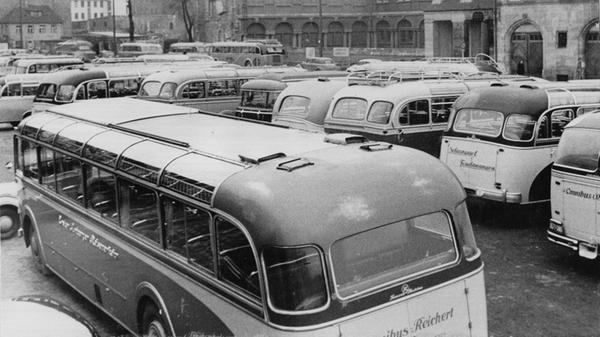 An einem verkaufsoffenen Sonntag im Jahre 1953 zog es viele Menschen in die Stadt. Während sich die Menschenmassen in den Straßen der Nürnberger Innenstadt drängten, standen auf den Parkplätzen brav die zahllosen Autobusse. Der Blick auf den Kornmarkt zeigt eine wahres Meer aus Omnibusdächern.