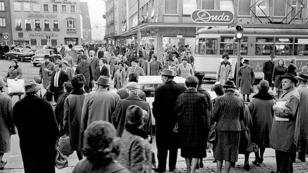 Sicher war es für Großstadt-Fußgänger um 1963 in Nürnberg nicht gerade. Autos und Straßenbahnen zogen am Knotenpunkt vor der Lorenzkirche in langen Ketten an ihnen vorüber. Zum Gang über die Straße blieb kaum Zeit.