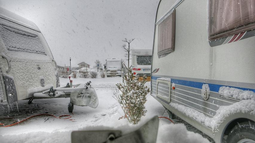 Der plötzliche Wintereinbruch hinterlässt seine Eisspuren an den Fahrzeugen auf dem Wintercampingplatz.
