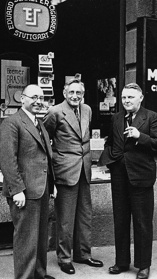 Bekannt wurde Ludwig Erhard durch den Posten als Wirtschaftsminister (1949-1963) und später als zweiter Bundeskanzler Deutschlands (1963-1966). Hier sieht man ihn mit seinem Markenzeichen, der Zigarre - passenderweise vor einem Tabakladen.