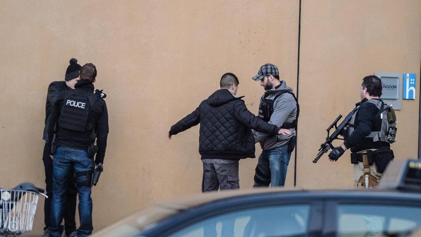 Bis wieder so etwas wie Normalität in Brüssel einkehrt, kann es dauern. Hier kontrolliert die Polizei Passanten - schwer bewaffnet.