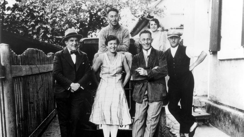 Die beiden Brüder und ihre Frauen auf einem Familienfoto: Auf dem Auto sitzend ist Adolf zu sehen, der zweite von rechts ist Rudolf.