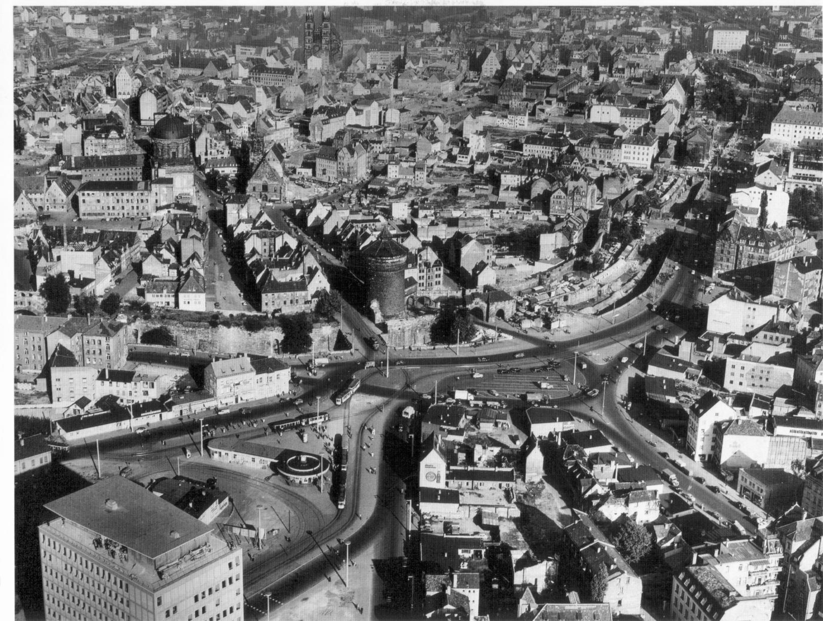 In den Nachkriegsjahren wurde der Platz, wie so viele Ecken Nürnbergs, in mühevoller Arbeit wieder hergerichtet. Hier ist der Plärrer 1953 mit Blick auf das Jakobsviertel zu sehen. Vorne links steht bereits das Gebäude der Stadtwerke.