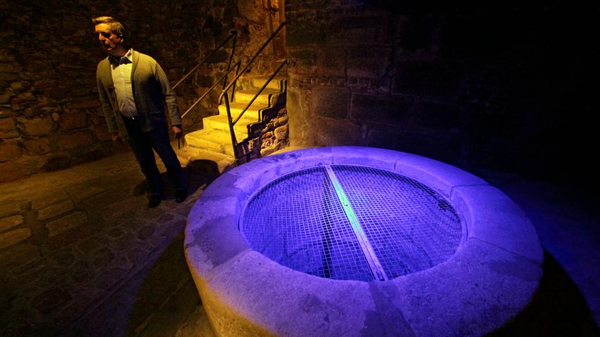 Blaues Licht beleuchtet den fünf Meter tiefen Brunnen, in den Touristen gerne Mün­zen werfen.