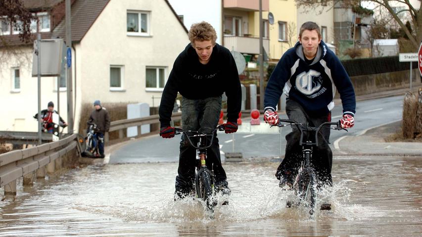 Keine Scheu vor nassen Füßen haben hier zwei junge Männer. Etwa bis zur Hälfte versinken ihre Räder im Wasser - 2006 in Stadeln.