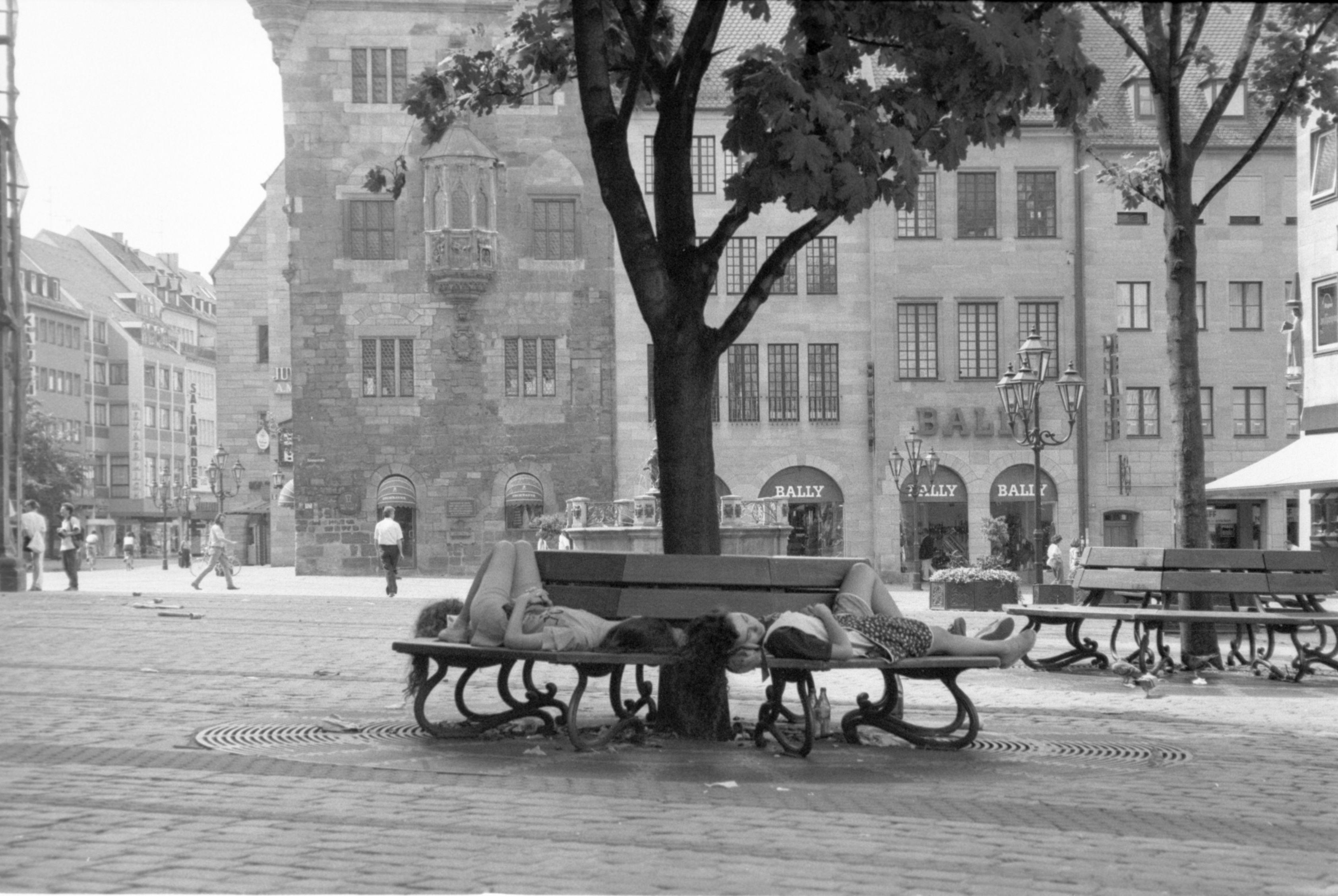 Schläfchen im Schatten: Junge Frauen erholten sich auf einer Bank bei der Lorenzkirche vom Bummel durch die hitzeerfüllte Altstadt. Sie blieben ungestört, denn die Fußgängerzone war in diesem Sommer 1992 fast menschenleer. Rekordwerte lieferte 1994 mit 55 Sommertagen.