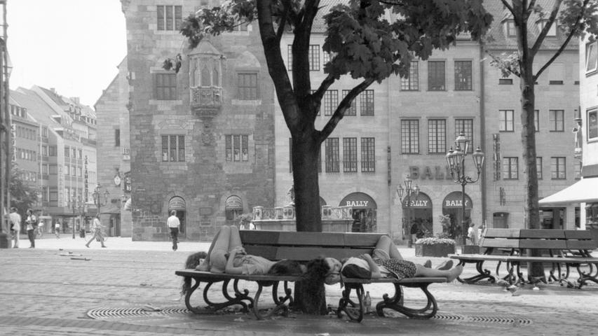 Schläfchen im Schatten: Junge Frauen erholten sich auf einer Bank bei der Lorenzkirche vom Bummel durch die hitzeerfüllte Altstadt. Sie blieben ungestört, denn die Fußgängerzone war in diesem Sommer 1992 fast menschenleer. Rekordwerte lieferte 1994 mit 55 Sommertagen. 