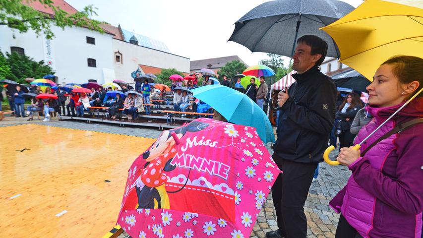 Geschützt von einem bunten Regenschirm bleibt der Kunstgenuss ungetrübt, den ...