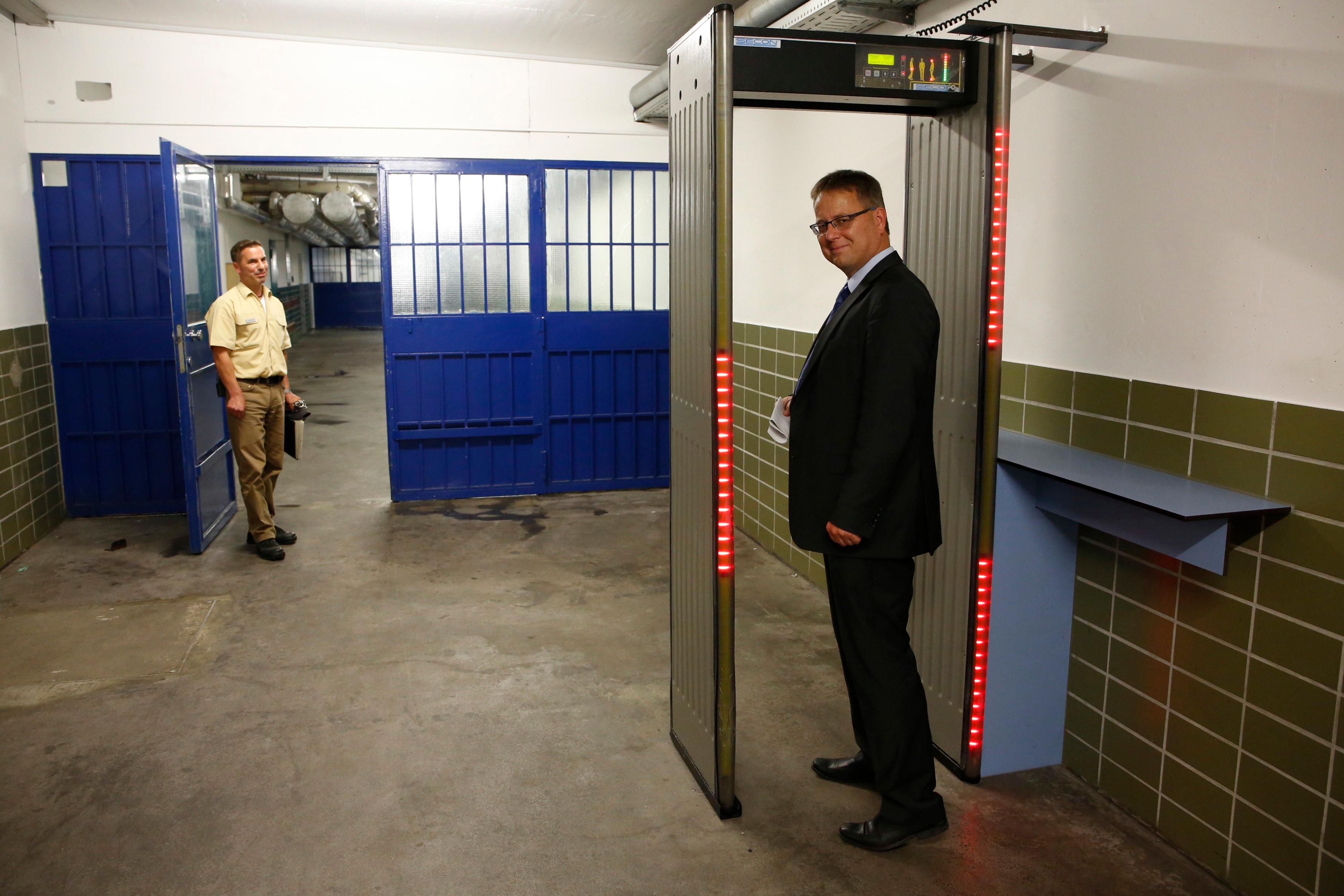 Am Über­gang steht ein Metalldetektor: Mit Hilfe der Detektoren wird in den Katakom­ben kontrolliert, ob die Gefangenen "unerlaubte Gegenstände" besitzen – nach ihrem Arbeitstag in der Schlosse­rei etwa eine Zange oder einen Schrau­benzieher einstecken haben.