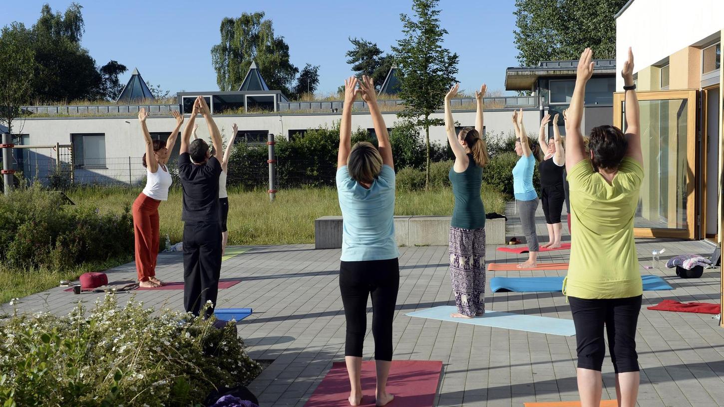 Idylle pur: Im Garten des Röthelheimpark-Treffs bereiten sich die Teilnehmer des Yoga-Kurses am frühen Morgen auf den Tag vor. Marisa Leininger (ganz links) leitet die Kursteilnehmer an.
