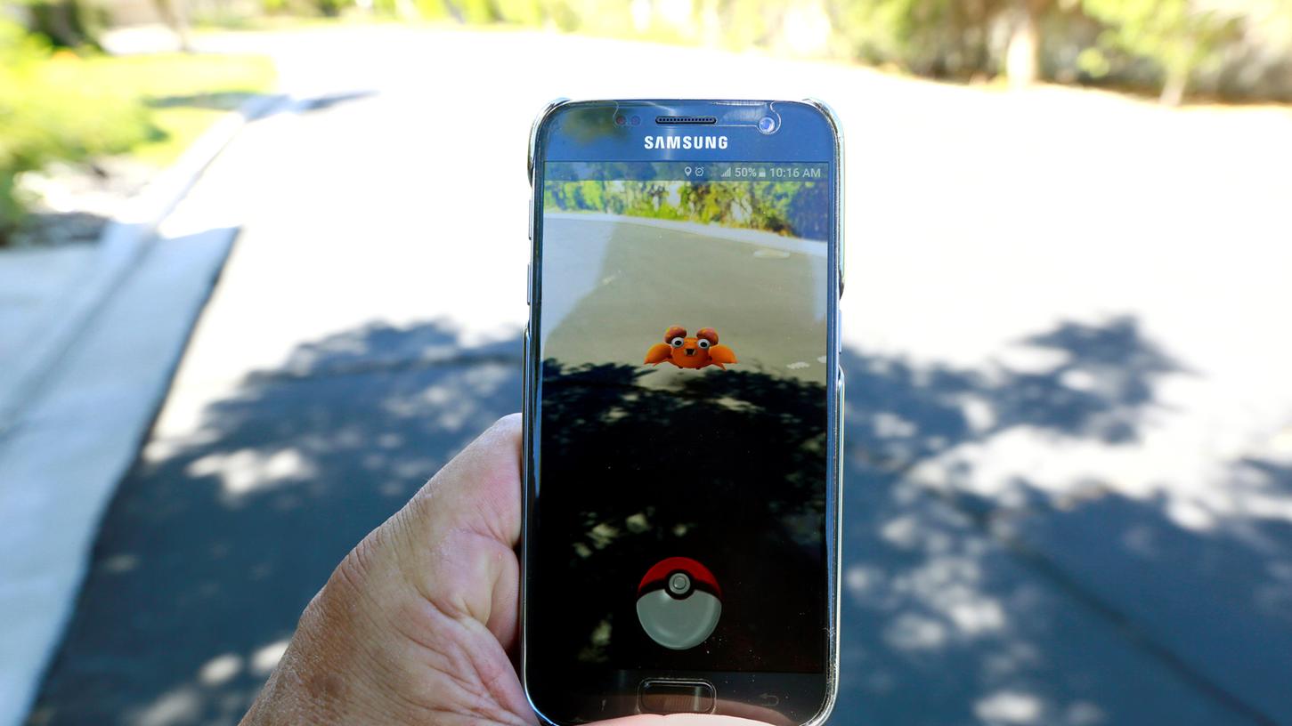 ie kostenlose Spiele-App Pokémon Go animiert die Nutzer, mit ihrem Smartphone durch die Gegend zu laufen und in der „echten Welt“ versteckte Pokémon-Figuren einzufangen. (Symbolbild)