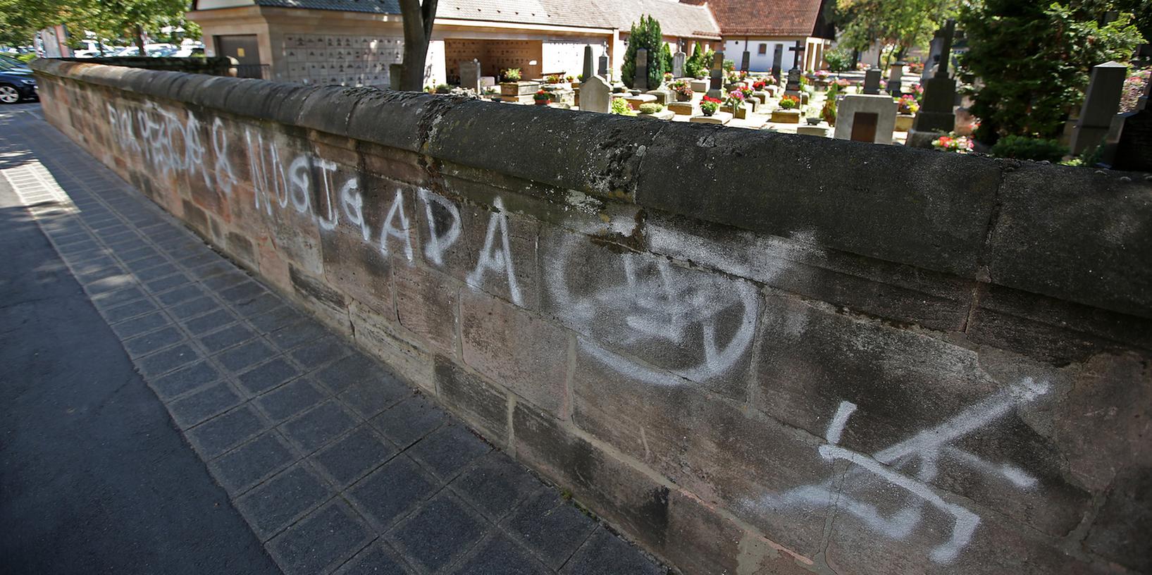 Das Hakenkreuz verschandelt die Sandsteinmauer des Rochusfriedhofs seit Februar 2015. Sör-Chef Christian Vogel bestätigt, dass seine Mitarbeiter das verbotene Symbol durchgestrichen haben. Bis es entfernt wird, dauert es noch. Was Anwohner ziemlich ärgerlich finden.