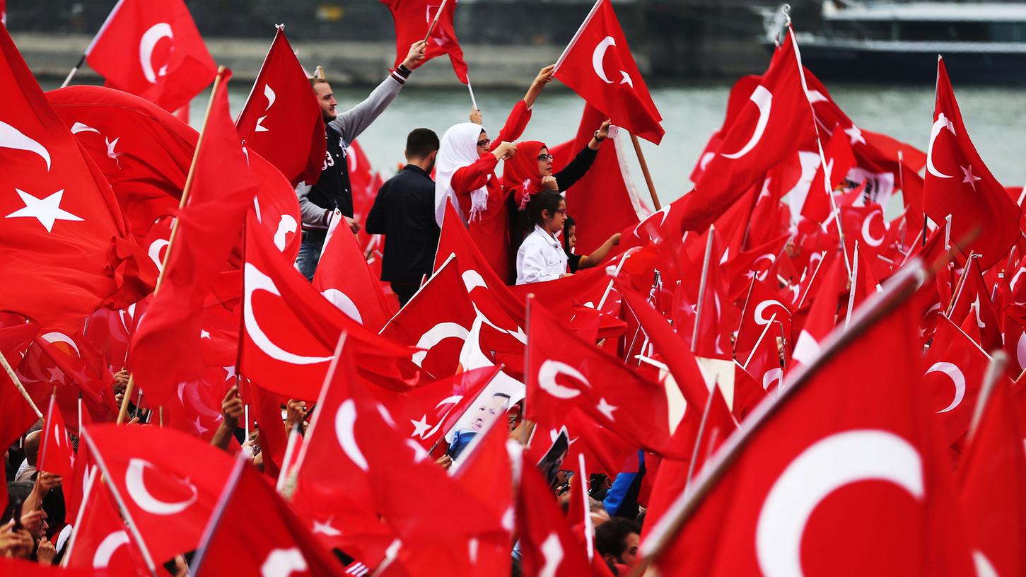 Anhänger des türkischen Staatspräsidenten Erdogan schwenken am 31.07.2016 in Köln (Nordrhein-Westfalen) türkische Fahnen.