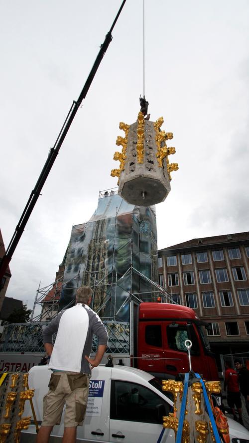 Ein besonderer Moment für viele Nürnberger: Der Schöne Brunnen auf dem Hauptmarkt erhielt nach monatelangen Restaurierungsarbeiten am Dienstag seine Spitze wieder.
