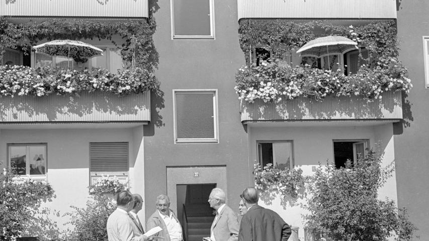 Geradezu 'umsponnen', nämlich mit wildem Wein, wirken diese Balkone im Blumenschmuck in der Poppenreuther Straße. Die Vertreter der Jury (vorn) diskutieren und vergeben die von den Teilnehmern begehrten Punkte.  Hier geht es zum Artikel vom 12. August 1966: Bunte Pracht verzaubert Häuser.