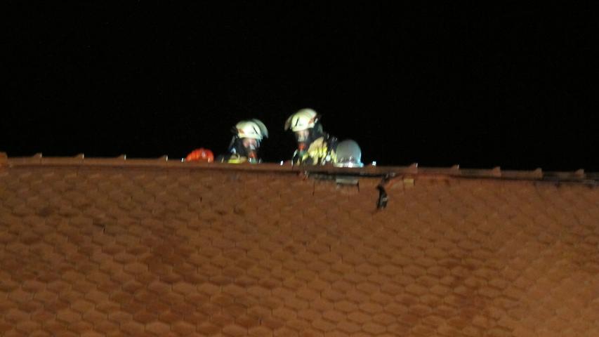 Brand in Forchheims Alter Wache: Zwei Einsatzkräfte der Forchheimer Wehr suchen im Dach noch nach Glutnestern.