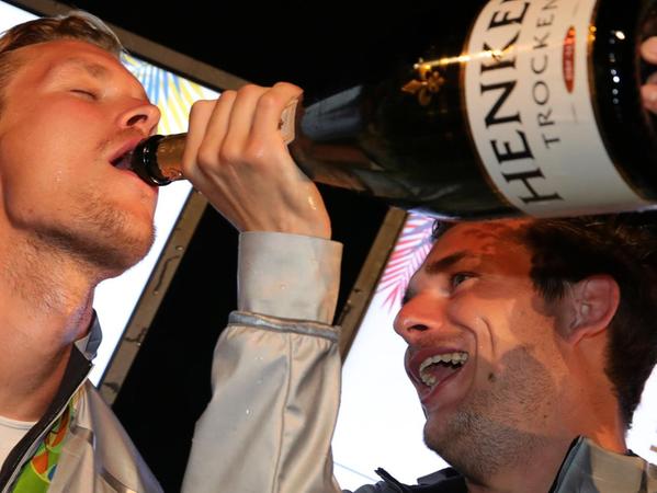 Eher feucht-fröhlich statt trocken: Christopher Wesley (re.) hält für Linus Butt die große Champagner-Flasche.